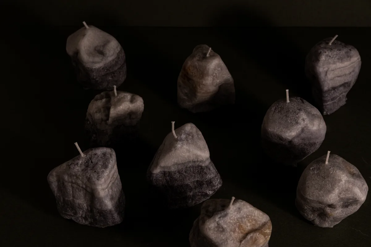 Sädemesaar candles shaped like glacial boulders, arranged on a dark surface